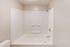 Modern bathroom featuring a sleek, white bathtub with built-in shower, offering a clean and relaxing space for unwinding.
