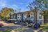 Charming apartment complex with modern exterior, surrounded by lush trees under a clear blue sky.
