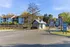 Inviting apartment complex with charming architecture, lush greenery, and a welcoming entrance to the leasing center under a bright, blue sky.