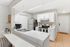 Modern kitchen with sleek white cabinets, stainless steel appliances, and a stylish breakfast bar.