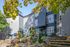 Modern apartment exterior with lush landscaping, vibrant autumn foliage, and contemporary design elements.
