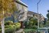 Charming apartment building with modern architecture, surrounded by lush greenery and autumn foliage.