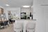 Modern apartment kitchen with granite countertop, cozy seating, and sleek appliances, leading to a stylish workspace.