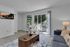 Bright and inviting living room with modern decor, featuring a plush sofa, stylish coffee table, and floor-to-ceiling sliding glass doors leading to a serene outdoor patio area.
