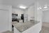 Modern kitchen with sleek granite countertops, elegant cabinetry, and stainless steel appliances in a bright, airy space.