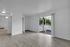 Bright and inviting living space featuring sleek wooden flooring, a private balcony with lush greenery views, and ample natural light.