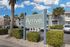 Inviting exterior of Arrive Key West with lush green surroundings and elegant sign, offering a warm welcome to residents.