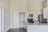 Modern kitchen with stainless steel appliances, sleek granite countertops, and open shelving.