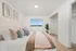 Elegant bedroom with a plush bed, neutral tones, large window view, and spacious open closet, ideal for comfort and tranquility.