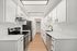 Sleek modern kitchen with white cabinetry, stainless steel appliances, and elegant wood flooring.