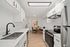 Modern kitchen with sleek white cabinetry, stainless steel appliances, and cozy dining nook, exuding elegance and functionality.