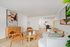 Inviting open-concept living space featuring modern art, stylish wooden furniture, and cozy seating area with soft lighting.