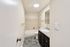 Bright and modern bathroom featuring a sleek vanity, spacious tub, and elegant tile flooring.