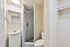 Modern bathroom featuring a sleek glass-enclosed shower, elegant vanity with mirror, and bright lighting creating an inviting atmosphere.