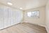 Bright and airy room featuring sleek wooden flooring, expansive windows with natural light, and ample closet space.