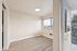 Bright and airy unfurnished room with large windows offering stunning views, elegant wood flooring, and modern lighting.