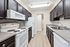 Modern kitchen featuring sleek dark cabinetry, bright white appliances, and polished countertops for an elegant touch.