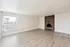 Bright, spacious living room with elegant wood flooring and a charming brick fireplace.