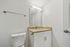 Contemporary bathroom with sleek granite countertop, stylish vanity, and modern fixtures.