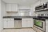 Modern kitchen with sleek stainless steel appliances, granite countertops, and elegant white cabinetry, offering a bright and inviting atmosphere.