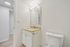 Modern bathroom with elegant granite countertop, sleek white vanity, and bright lighting.
