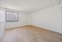 Bright and spacious room with modern wood flooring and large window offering plenty of natural light.