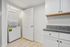 Modern utility room featuring a sleek stackable washer and dryer with elegant granite countertops and ample storage cabinets.
