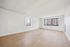 Bright and spacious living room with large windows and elegant hardwood flooring, perfect for modern living.