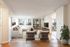 Chic and spacious living room with modern furniture, floor-to-ceiling windows, and open flow into a bright dining area, ideal for urban living.
