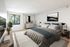 Elegant bedroom featuring a plush bed with cozy linens, modern artwork, and a scenic view through a large window.