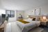 Elegant bedroom with a cozy king-sized bed, stylish decor, large window with city views, and modern furniture.