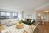 Bright, open-concept living room with panoramic city views, featuring modern decor, plush seating, and a warm wood floor.