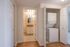 Charming apartment corner featuring a modern in-unit laundry area and a view into a stylish bathroom with granite countertops.
