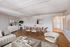 Modern living area featuring elegant furniture, a chic dining table, and warm wood floors creating a cozy and inviting atmosphere.