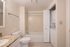 Chic and inviting bathroom featuring a granite countertop, modern fixtures, and in-unit washer and dryer for added convenience.