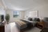 Inviting bedroom with a large window offering picturesque views, elegant decor, and cozy bedding for a perfect retreat.