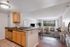 Modern open-concept apartment with a stylish kitchen, cozy living room, and scenic window view.