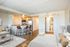 Contemporary studio apartment featuring an open-plan kitchen with modern amenities, cozy living area, and inviting wooden flooring.
