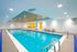 Luxurious indoor pool with modern lounge area and sleek design, perfect for relaxation and entertainment.