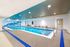Sleek indoor swimming pool with modern design, featuring a vibrant wall mural and ample seating, perfect for relaxation and leisure.