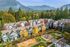 Charming townhouse community nestled in lush woodland with stunning mountain views, featuring colorful autumn foliage and a vibrant playground area.