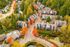 Charming neighborhood aerial view with colorful autumn trees surrounding elegant townhouses, offering serene living and community vibe.