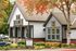 Charming community welcome center surrounded by lush greenery and autumn leaves, offering a warm and inviting atmosphere.