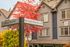 Charming residential street view with a vibrant tree in autumn colors, stylish gray buildings, and decorative street signs for Quartz Drive SW and Rock Creek Ridge Blvd.