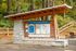 Inviting Tennant Trailhead Park entrance featuring a detailed trail map and rustic wooden structure set against a backdrop of lush greenery.