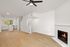 Bright, modern living space featuring a cozy fireplace, sleek open kitchen, and stylish wood flooring.