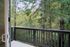 Peaceful balcony view overlooking lush green forest, offering a serene natural retreat.