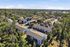 Townhomes at TSC Charming aerial view of a lush, green apartment community nestled in a tranquil, wooded area with modern buildings and ample parking.