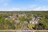 Townhomes at TSC Scenic aerial view of a spacious residential community surrounded by lush greenery, featuring modern buildings and tranquil tree-lined pathways.