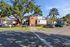 Townhomes at TSC Charming apartment complex featuring modern brick and siding architecture, surrounded by lush trees and ample parking.
